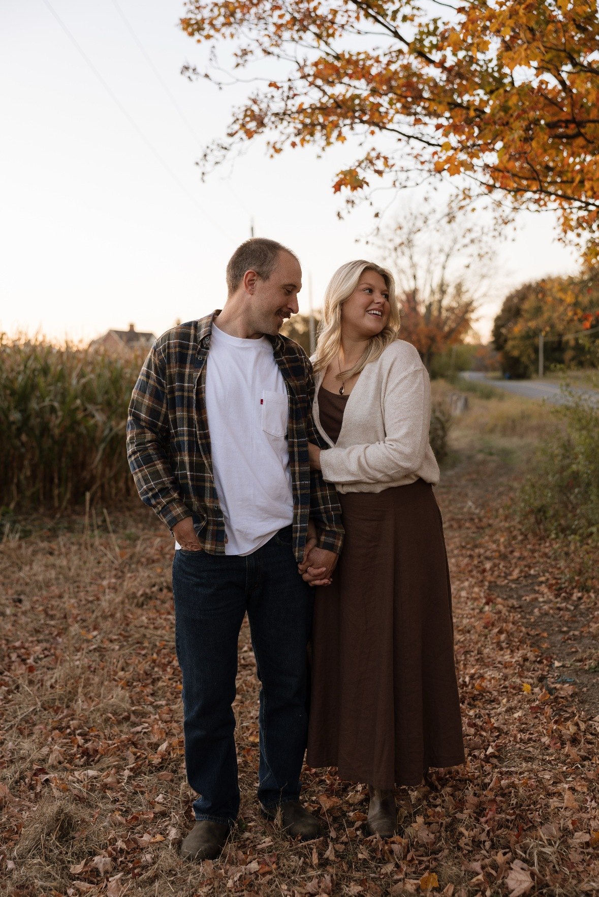 Couple walking hand in hand down an autumn lane