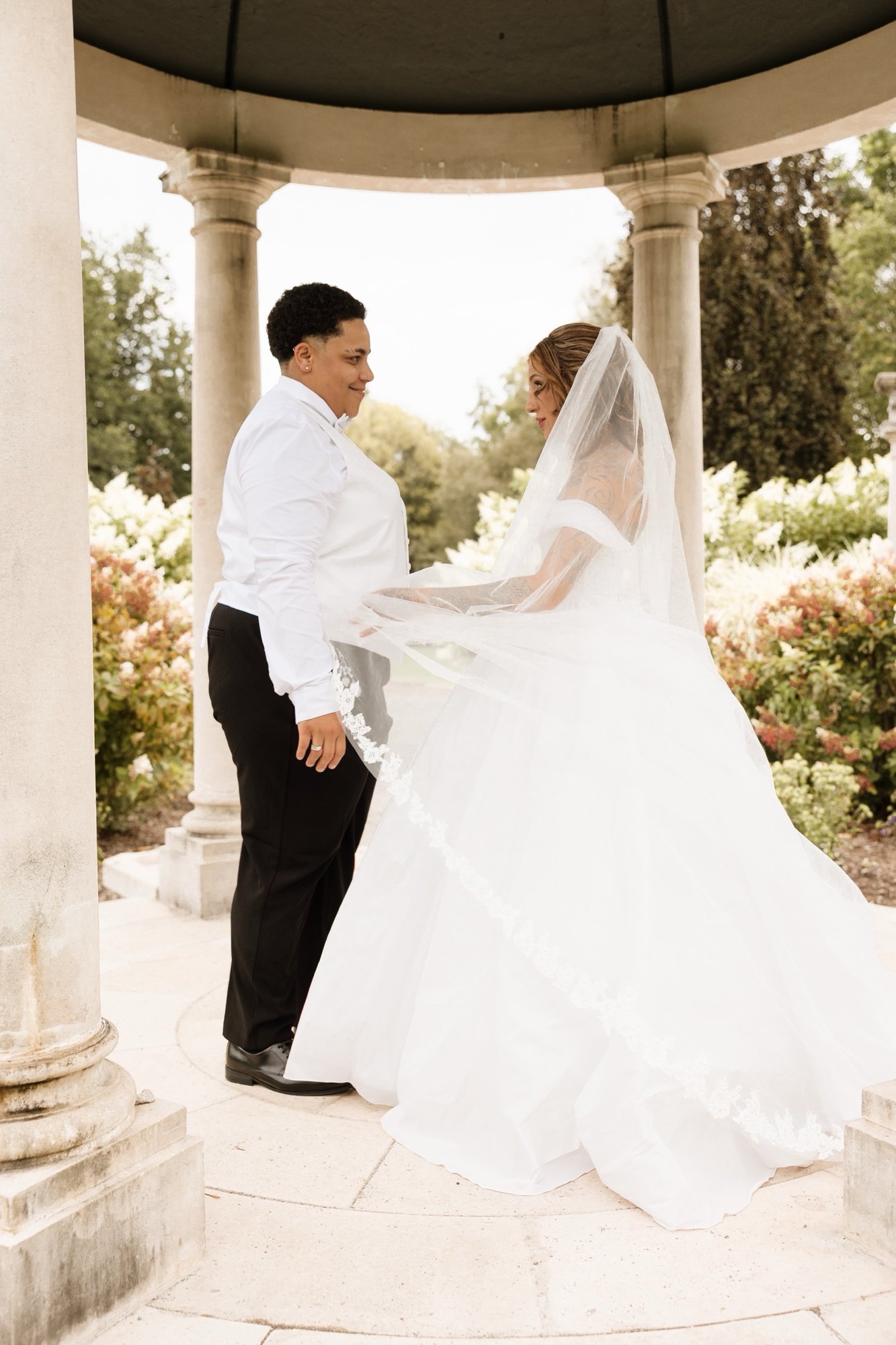 Bride and groom standing inside a garden gazebo