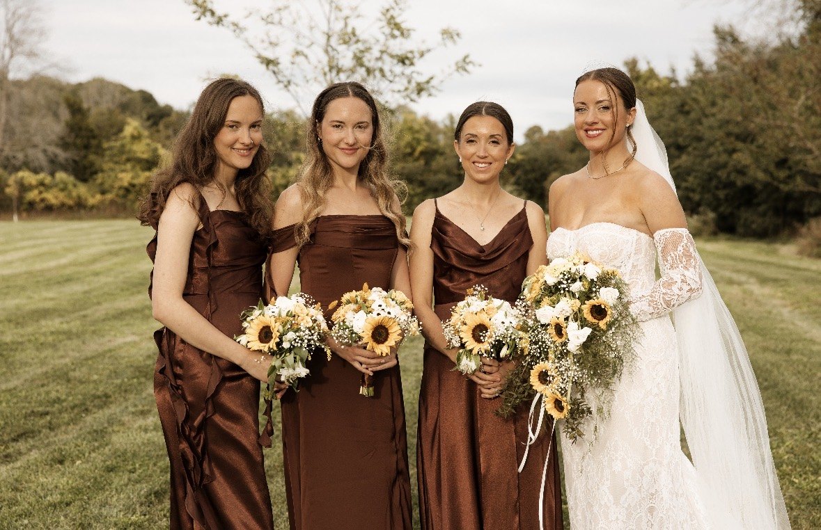 Bride with her bridesmaids holding sunflower bouquets